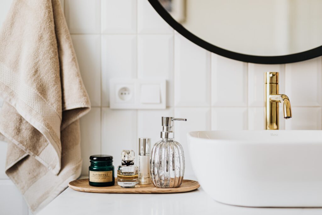 A bathroom counter with soap and lotion on it.