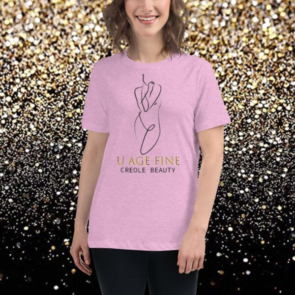 A woman wearing a pink t-shirt with gold lettering.