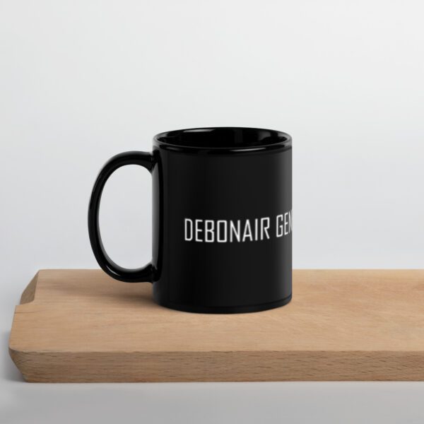 A black coffee mug sitting on top of a wooden table.