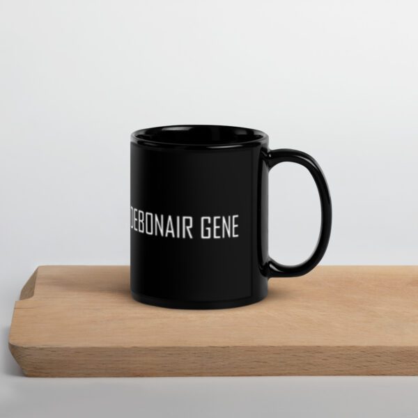 A black mug sitting on top of a wooden table.