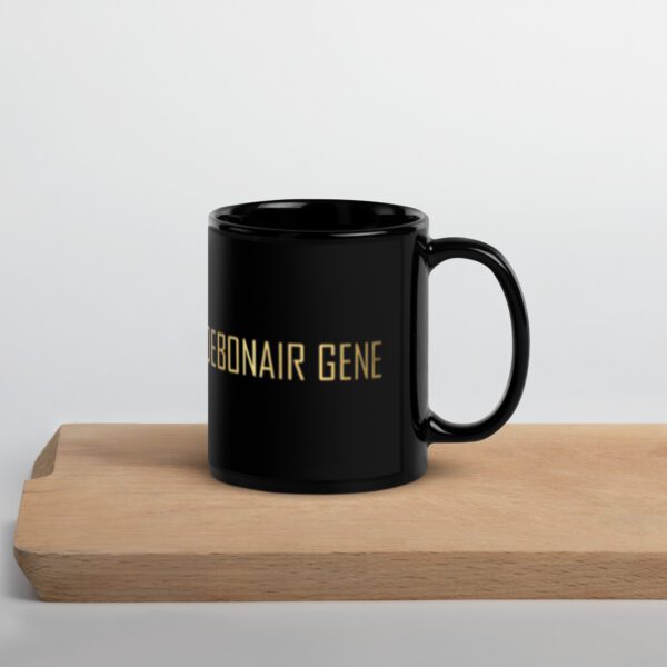 A black coffee mug sitting on top of a wooden table.