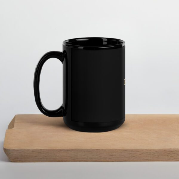 A black coffee mug sitting on top of a wooden table.